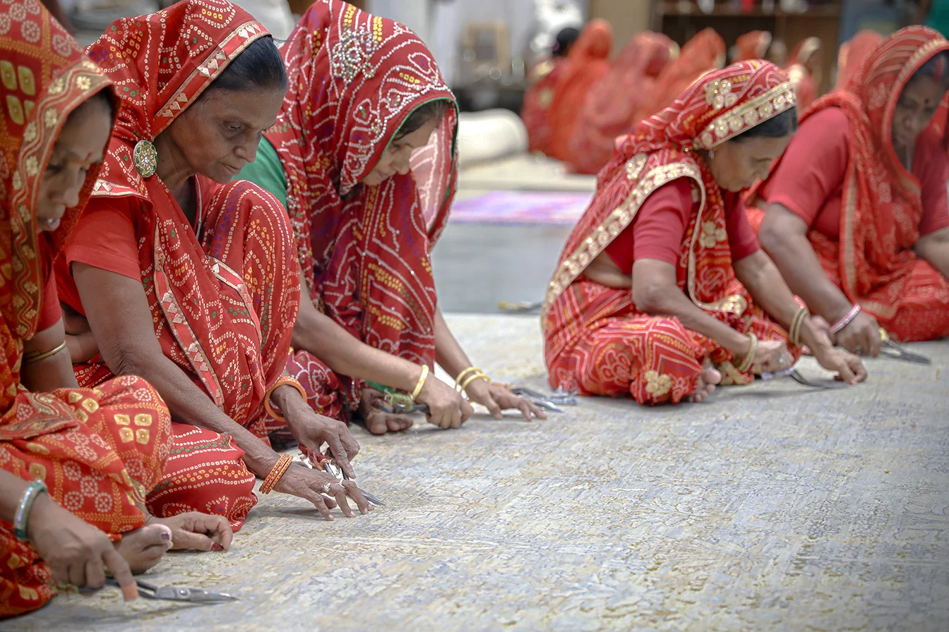 Artisans hand knotting rugs